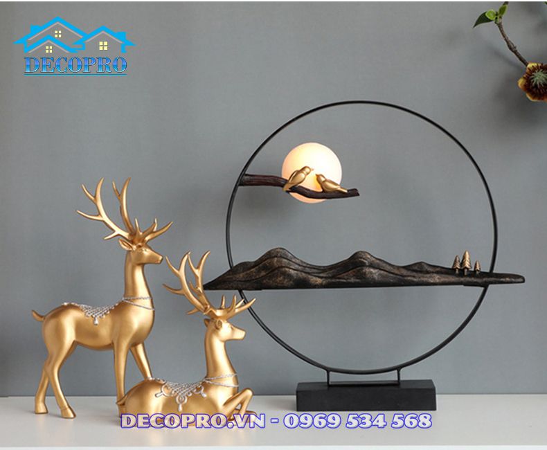 Cặp hươu một đứng một nằm đang nhàn nhã hướng về chiếc đèn